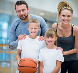 Parents and kids at gym holding basketball