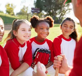 YMCA Softball players talk to their coach