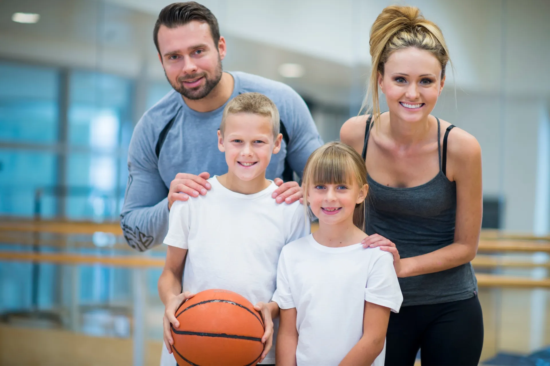 Parents and kids at gym holding basketball