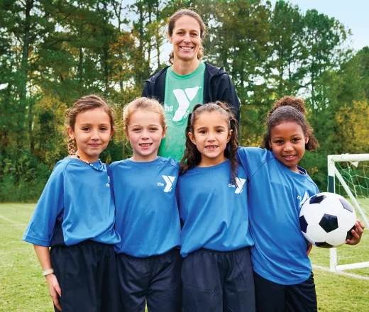 Happy YMCA Youth Sports Coach with Team